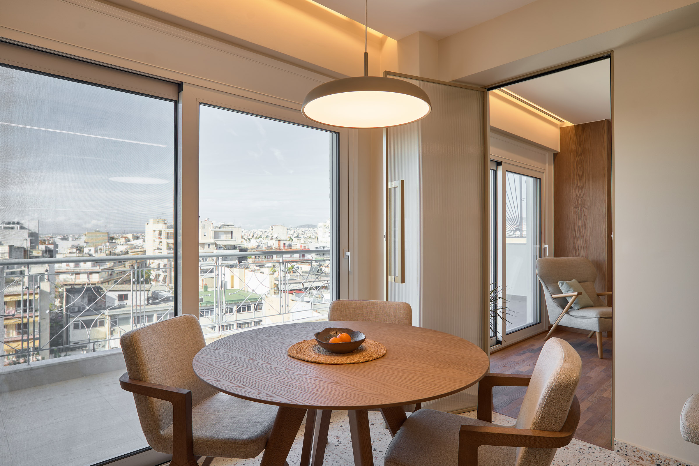 Dining room of a renovated apartment in Thessaloniki with large openings and city view