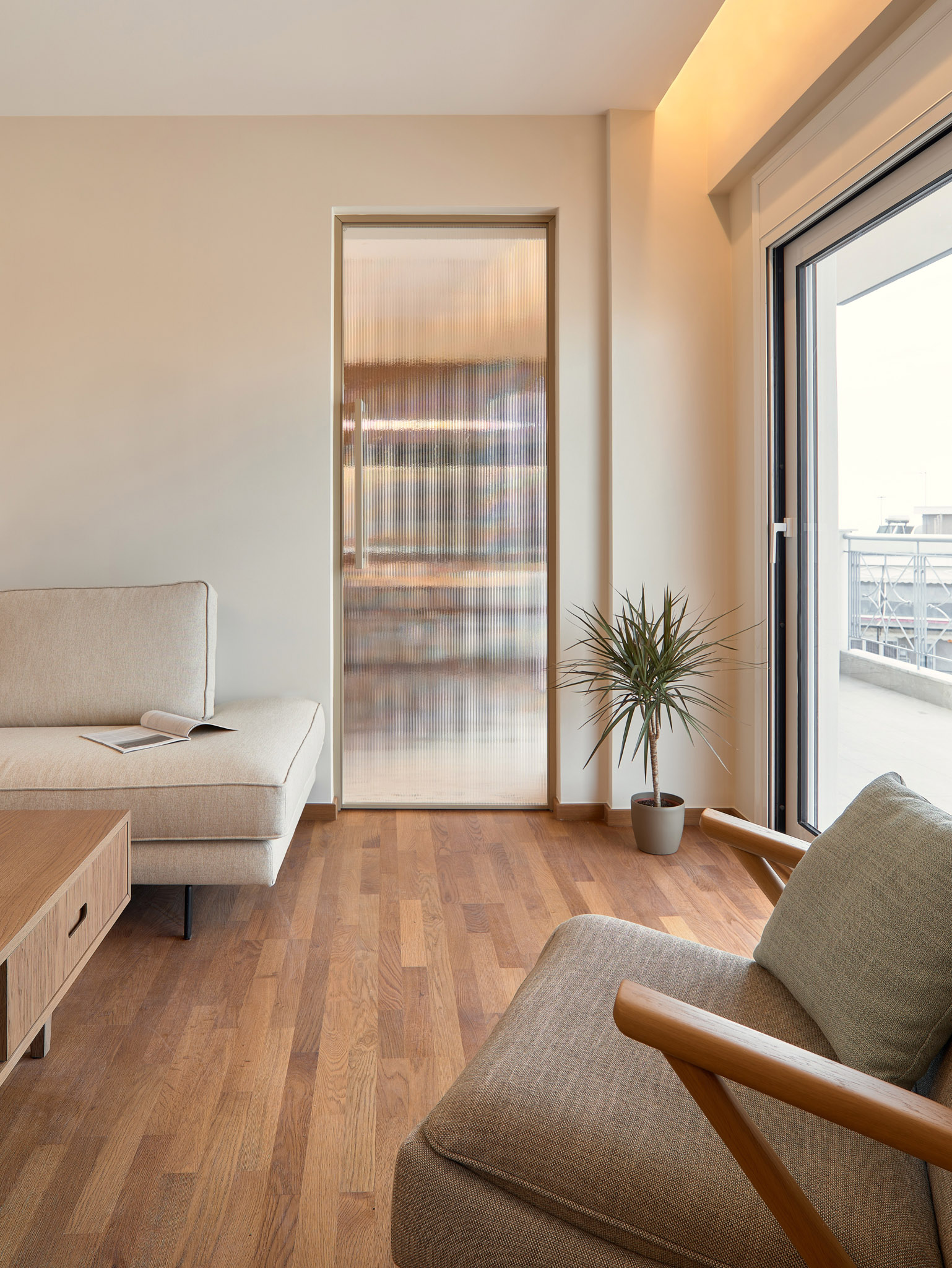 Living room of a renovated apartment in Thessaloniki with large openings and city view - glass door